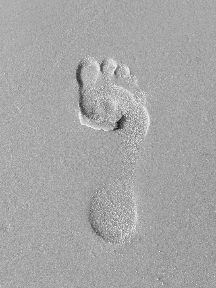 A footprint in the white sand