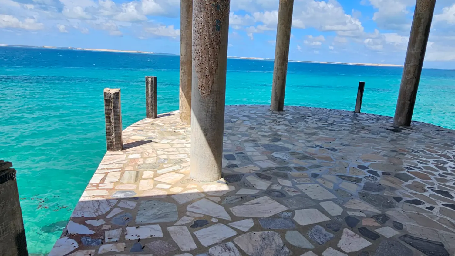 A stone jetty over the turquoise water of the archipelago